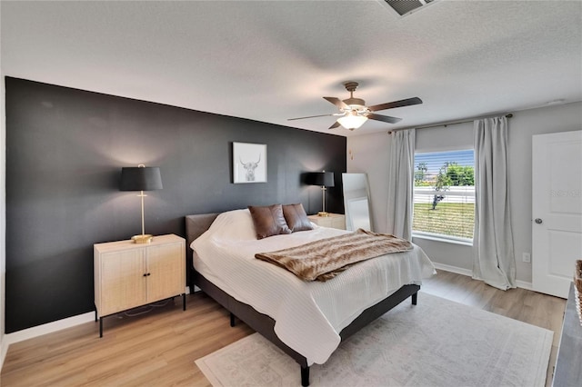 13506 Wild Ginger St, Riverview, FL 33579 - bedroom featuring light wood-style flooring, ceiling fan, and a textured ceiling
