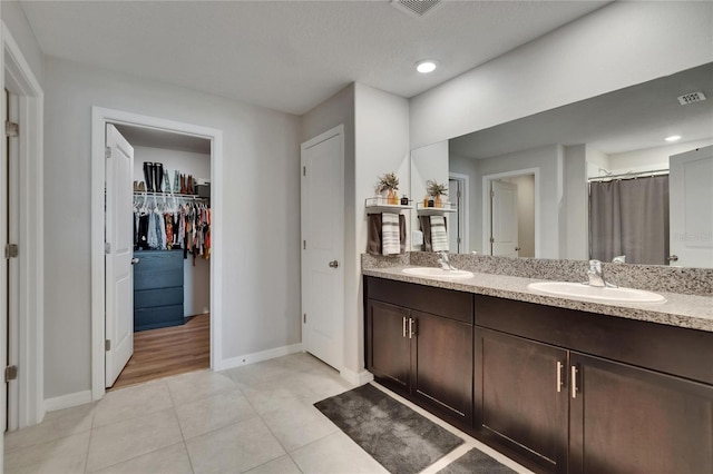 13506 Wild Ginger St, Riverview, FL 33579 - bathroom with double vanity, tile patterned flooring, a spacious closet, recessed lighting, and curtained shower