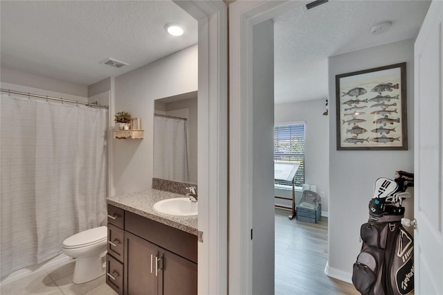 13506 Wild Ginger St, Riverview, FL 33579 - bathroom featuring vanity, a textured ceiling, wood finished floors, and a shower with shower curtain