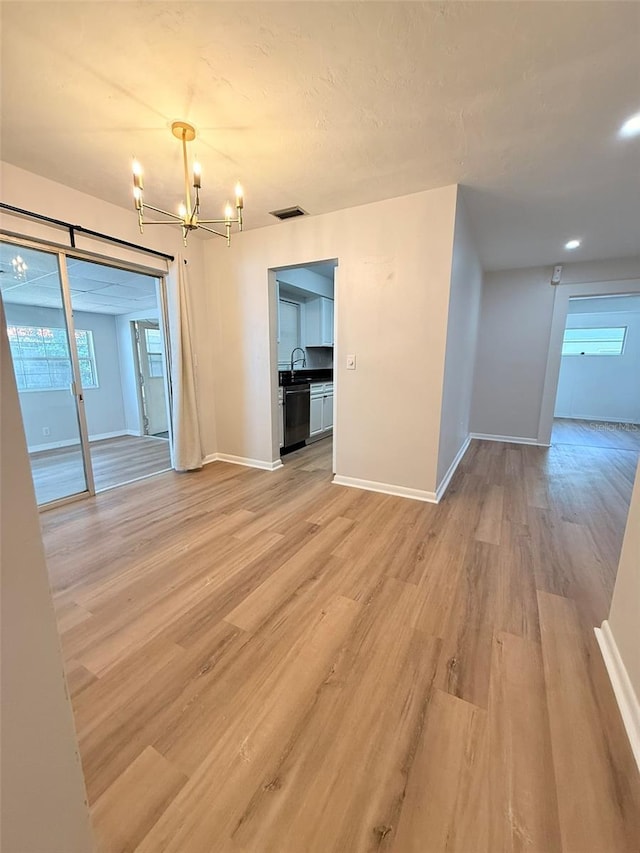 1505 Piedmont Dr, Deltona, FL 32725 - empty room with a chandelier, light wood finished floors, and baseboards