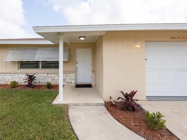 entrance to property with a lawn and stucco siding