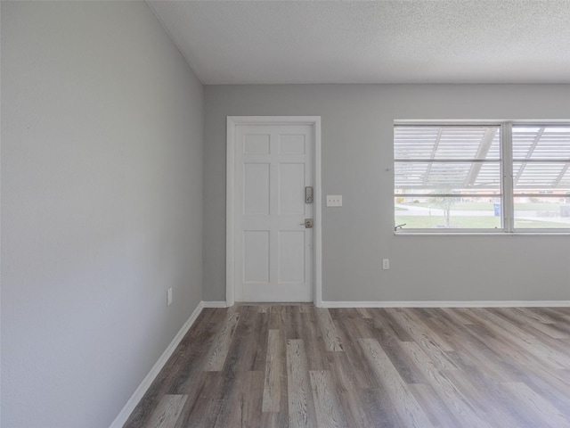 empty room with wood finished floors and baseboards