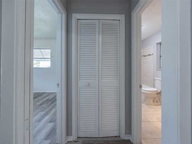corridor with wood finished floors and a textured ceiling