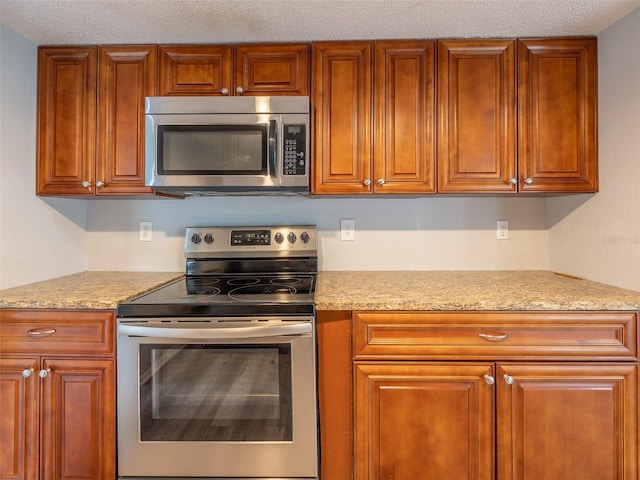 kitchen featuring stainless steel appliances and brown cabinets