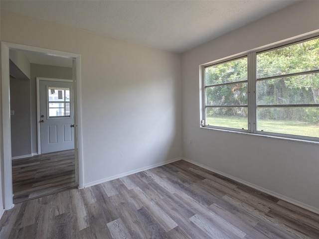 unfurnished room featuring baseboards and wood finished floors