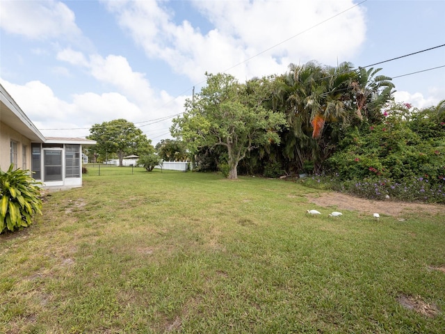 view of yard featuring a sunroom and fence