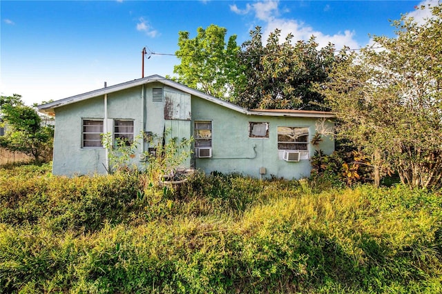 view of side of property featuring stucco siding and cooling unit