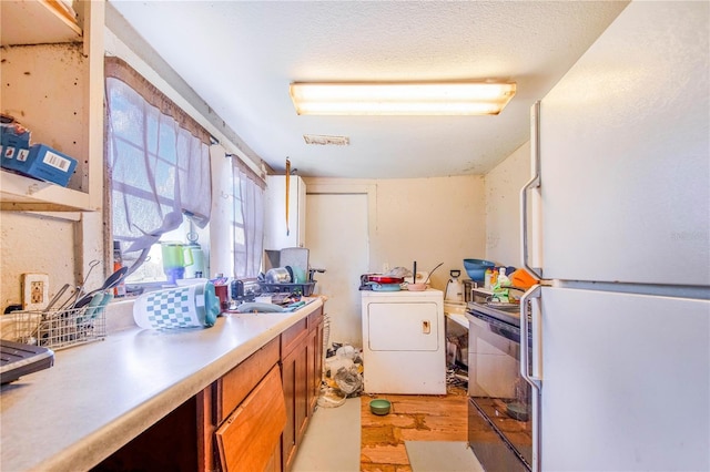 clothes washing area featuring washer / clothes dryer, light wood-style flooring, and laundry area