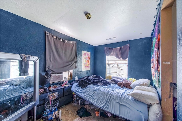 bedroom featuring a textured ceiling and a textured wall