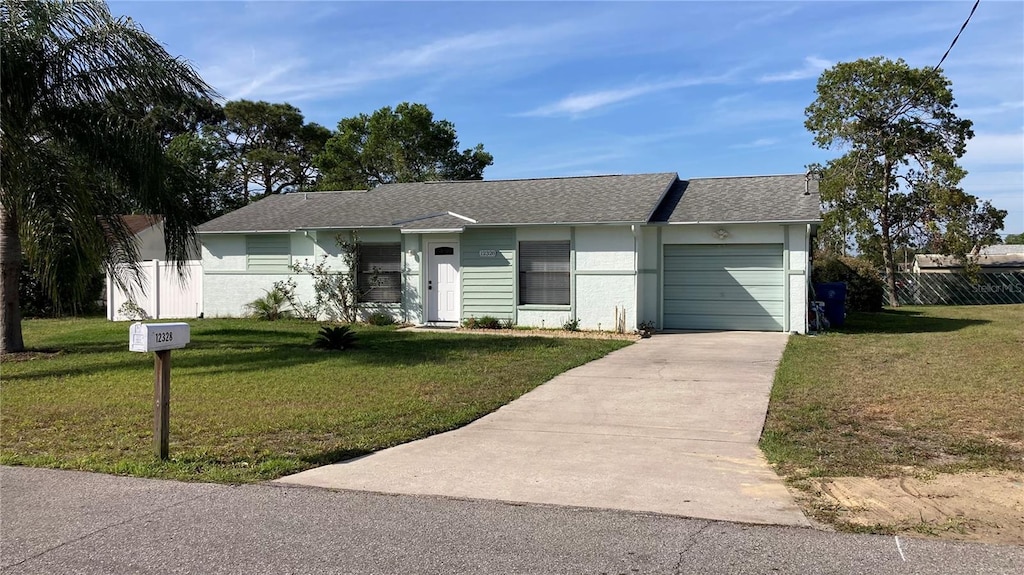 12328 Shafton Rd, Spring Hill, FL 34608 - ranch-style home featuring a garage, a front lawn, concrete driveway, and fence