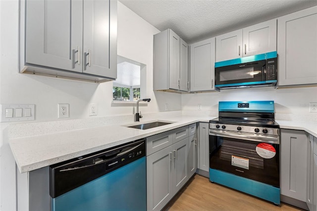 kitchen with a sink, stainless steel electric stove, light wood-type flooring, dishwashing machine, and gray cabinetry