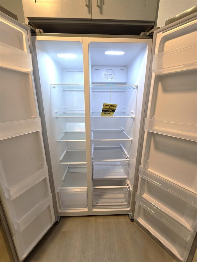 details with wood finished floors and refrigerator
