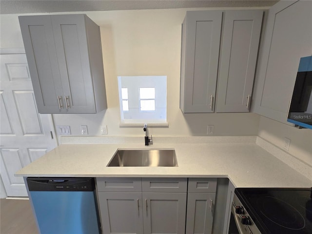 kitchen with light countertops, stainless steel range with electric stovetop, a sink, gray cabinetry, and dishwasher