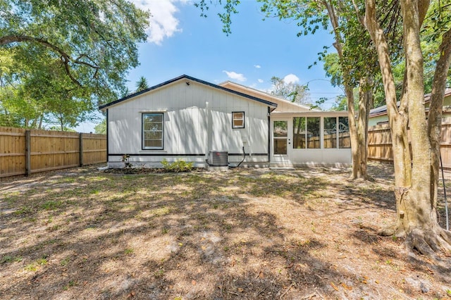 rear view of property featuring a sunroom, a fenced backyard, and central AC
