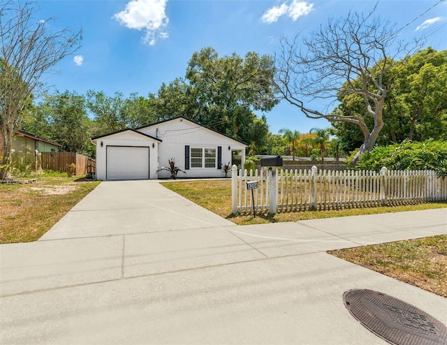 single story home with an attached garage, a fenced front yard, driveway, and a front lawn