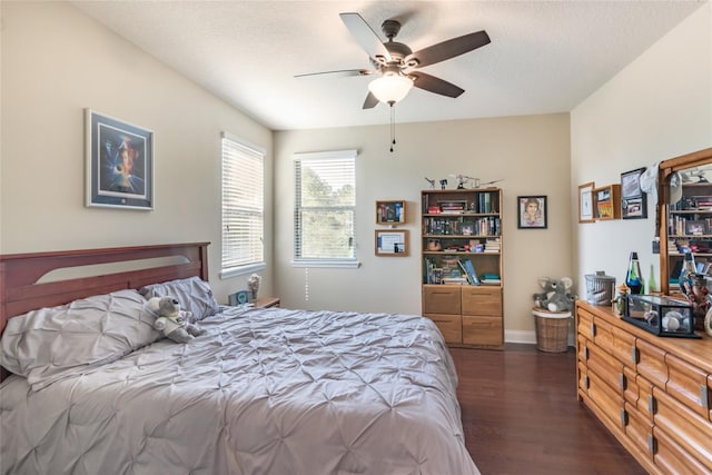 bedroom featuring baseboards, a ceiling fan, and dark wood finished floors
