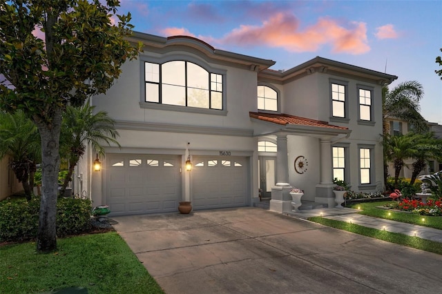 15630 N Himes Ave, Tampa, FL 33618 - mediterranean / spanish-style home featuring concrete driveway, an attached garage, a tiled roof, and stucco siding