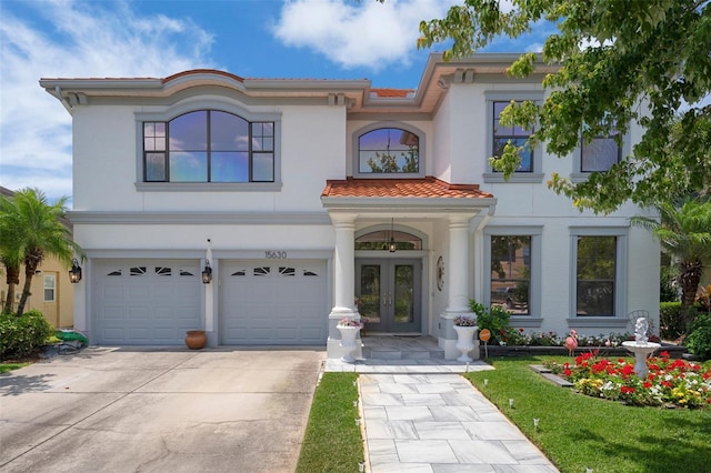 15630 N Himes Ave, Tampa, FL 33618 - mediterranean / spanish house with stucco siding, an attached garage, driveway, and french doors