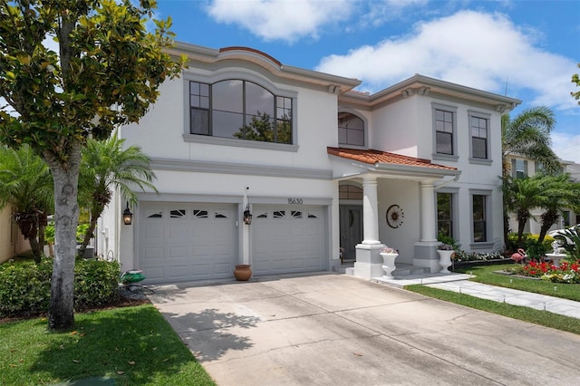 15630 N Himes Ave, Tampa, FL 33618 - mediterranean / spanish-style home with a garage, a tile roof, driveway, and stucco siding