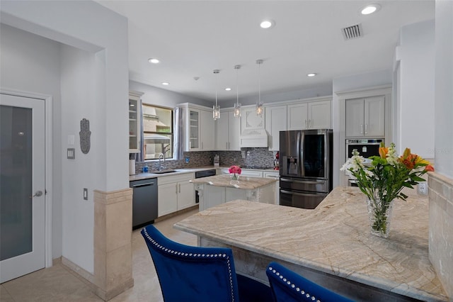 15630 N Himes Ave, Tampa, FL 33618 - kitchen featuring a sink, tasteful backsplash, visible vents, white cabinetry, and appliances with stainless steel finishes