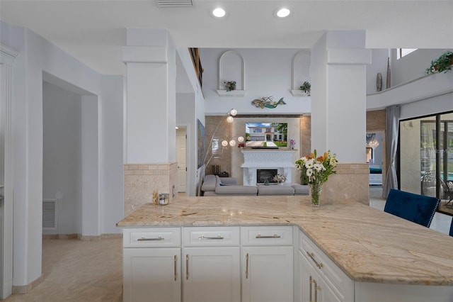 15630 N Himes Ave, Tampa, FL 33618 - kitchen featuring visible vents, recessed lighting, white cabinetry, light stone countertops, and a fireplace
