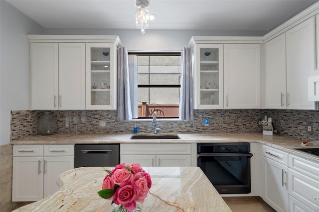 15630 N Himes Ave, Tampa, FL 33618 - kitchen with a sink, white cabinetry, decorative backsplash, dishwashing machine, and black oven