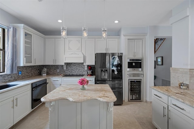 15630 N Himes Ave, Tampa, FL 33618 - kitchen with black appliances, backsplash, white cabinetry, wine cooler, and a kitchen island