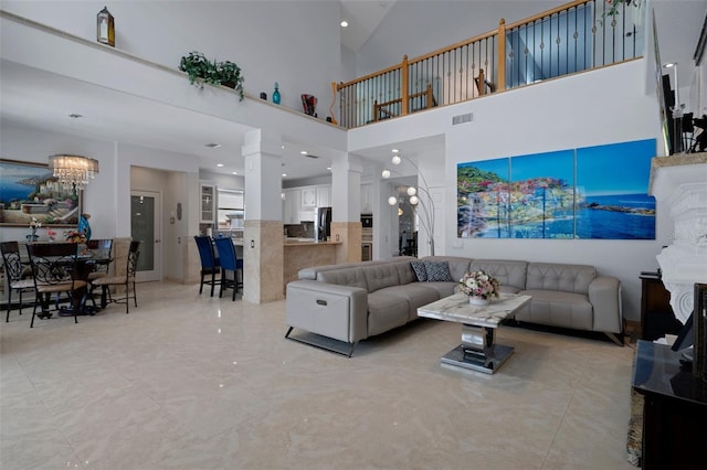 15630 N Himes Ave, Tampa, FL 33618 - living room with visible vents, a notable chandelier, ornate columns, marble finish floor, and high vaulted ceiling