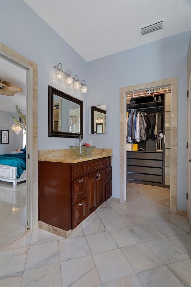15630 N Himes Ave, Tampa, FL 33618 - full bathroom with vanity, visible vents, a spacious closet, marble finish floor, and ensuite bath
