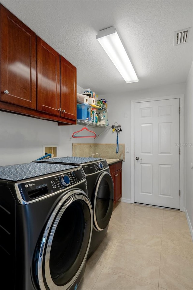 15630 N Himes Ave, Tampa, FL 33618 - laundry area featuring visible vents, light tile patterned floors, baseboards, washer and dryer, and cabinet space