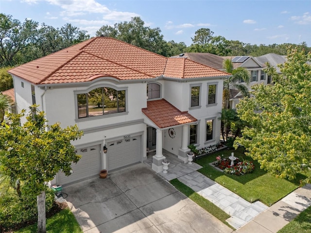 15630 N Himes Ave, Tampa, FL 33618 - mediterranean / spanish-style house with an attached garage, a tiled roof, stucco siding, and driveway
