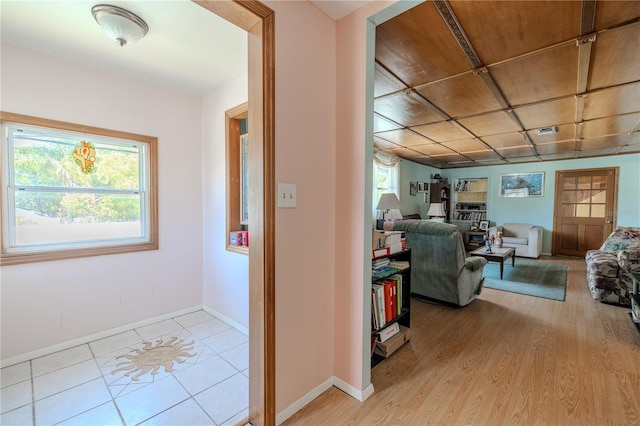 hall with visible vents, plenty of natural light, and baseboards