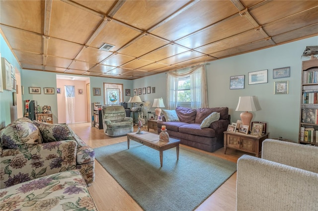 living area featuring visible vents and wood finished floors