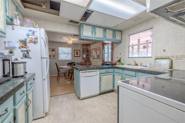 kitchen featuring range, dishwasher, light wood finished floors, a sink, and a peninsula