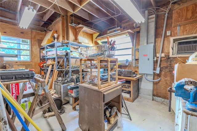 misc room featuring a workshop area, wood walls, concrete flooring, and plenty of natural light