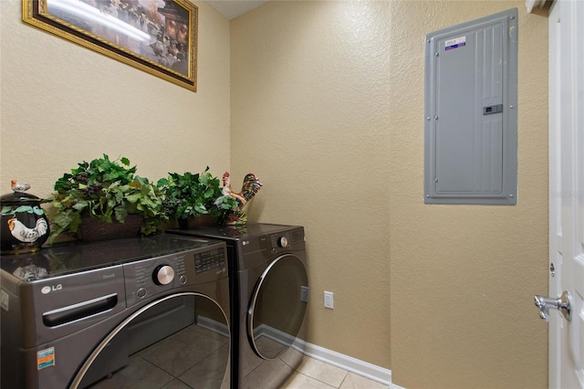 laundry room featuring laundry area, light tile patterned floors, electric panel, washing machine and clothes dryer, and baseboards
