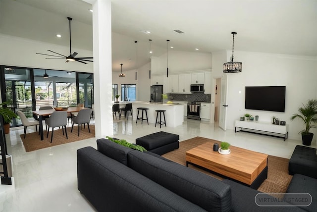 living room featuring a ceiling fan, recessed lighting, high vaulted ceiling, and a chandelier