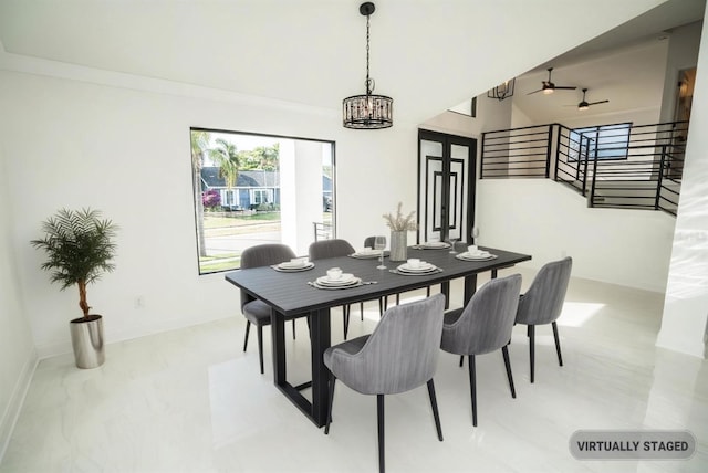 dining area with stairs, ceiling fan, a chandelier, baseboards, and light marble finish floors