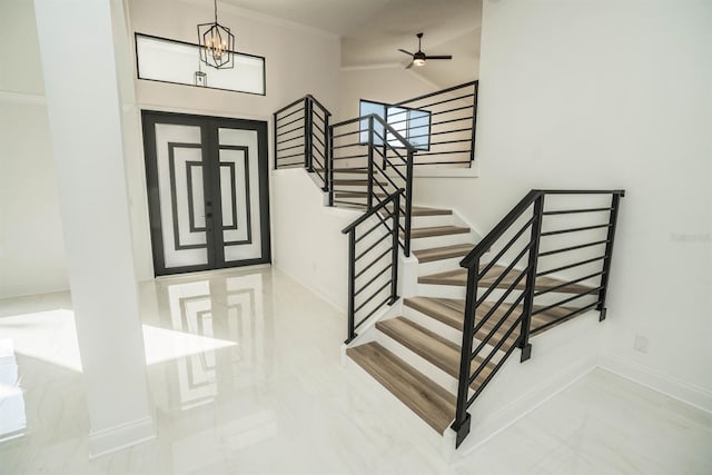 foyer with baseboards, stairway, ornamental molding, a chandelier, and lofted ceiling