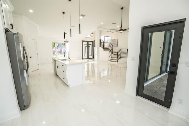 kitchen with freestanding refrigerator, light marble finish flooring, white cabinetry, light countertops, and recessed lighting