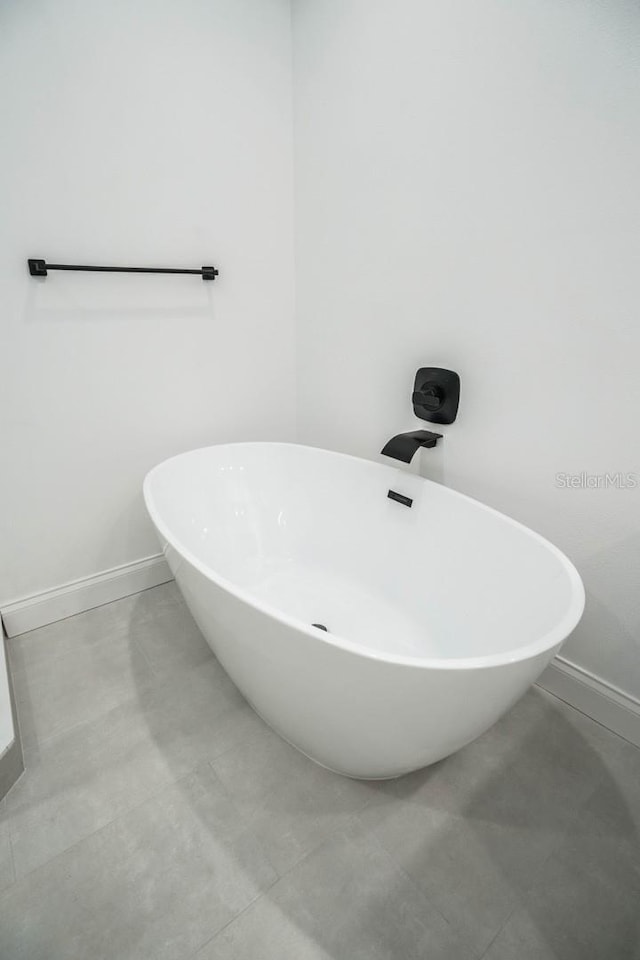 full bath featuring baseboards and a freestanding bath