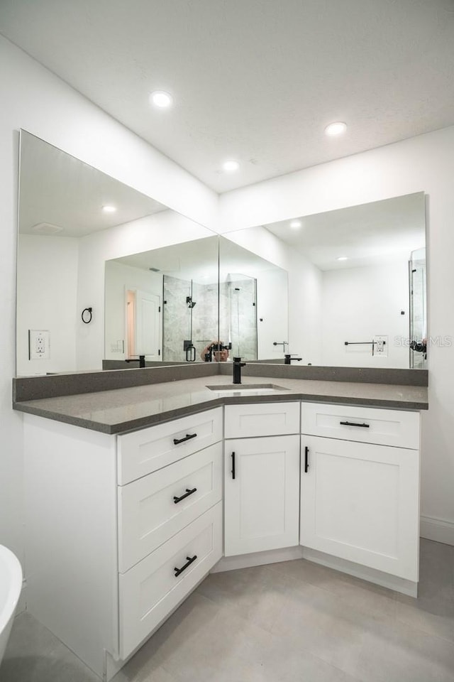full bathroom with vanity, recessed lighting, a stall shower, and baseboards
