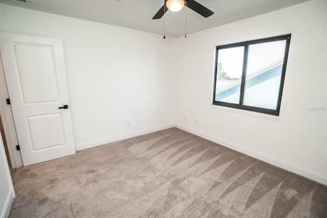 spare room with carpet flooring, a ceiling fan, and baseboards
