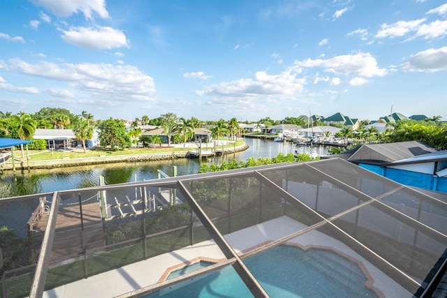 view of swimming pool featuring a water view, a lanai, a pool with connected hot tub, and a patio area