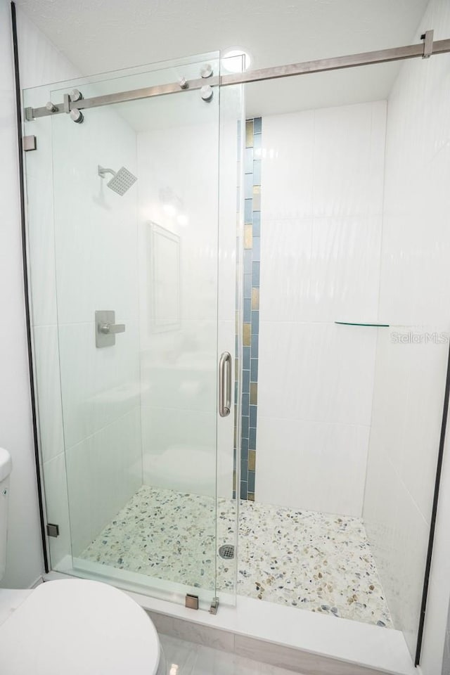 full bath featuring toilet and a stall shower