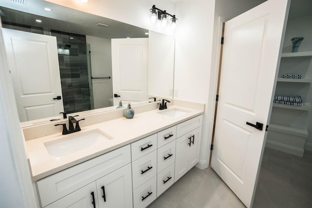 full bath featuring tiled shower, double vanity, and marble finish floors