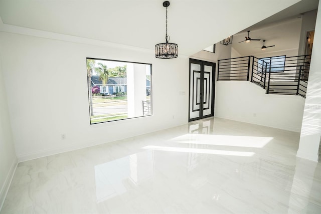 unfurnished room featuring stairs, marble finish flooring, a chandelier, vaulted ceiling, and baseboards