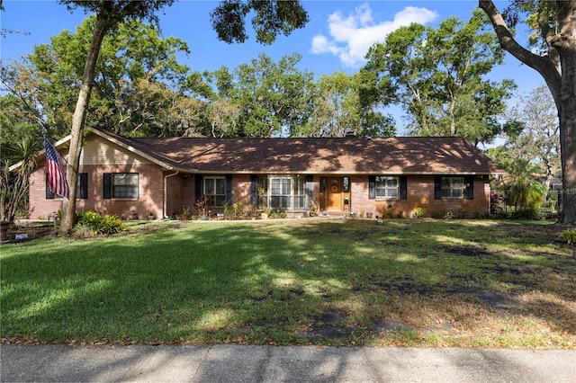single story home featuring brick siding and a front lawn