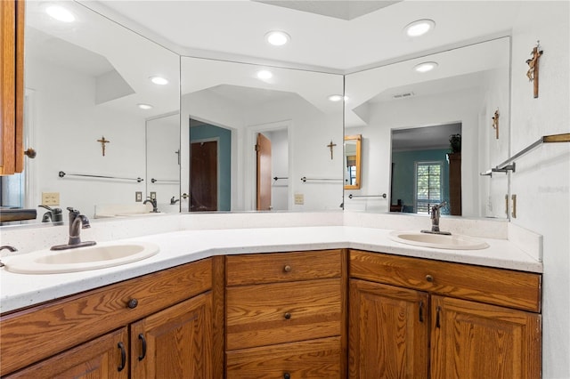 bathroom with recessed lighting, a sink, and double vanity