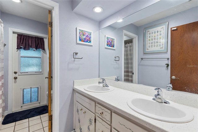 bathroom with double vanity, a sink, and tile patterned floors